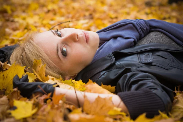 Young pretty girl lying on a foliage — Stock Photo, Image