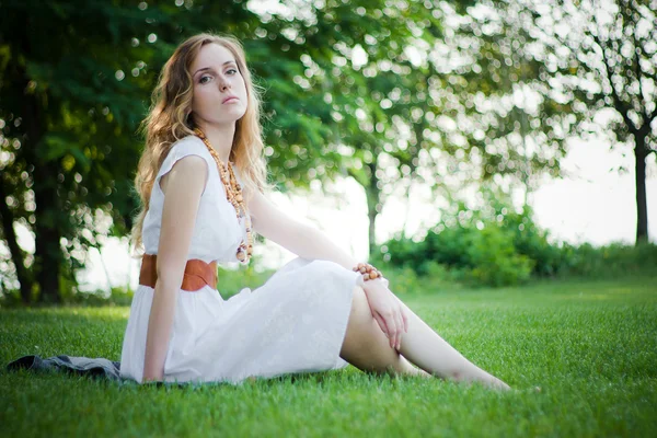 Pretty girl sits on the grass — Stock Photo, Image