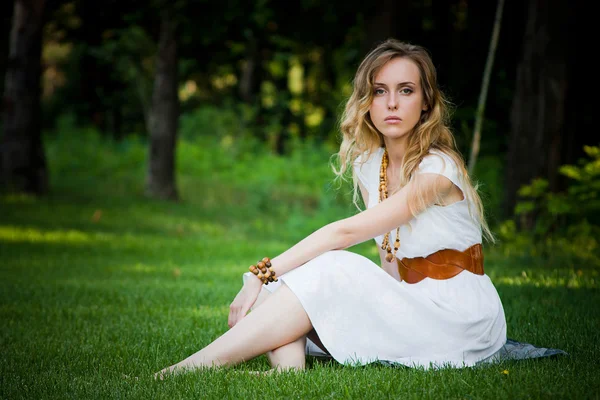 Beautiful girl sits on the grass — Stock Photo, Image