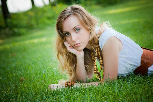 Piękna dziewczyna leży na trawie — Zdjęcie stockowe