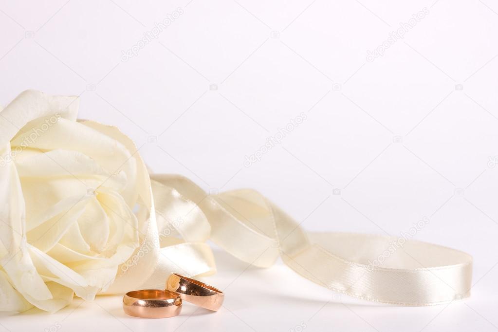 White rose, wedding ring and ribbon