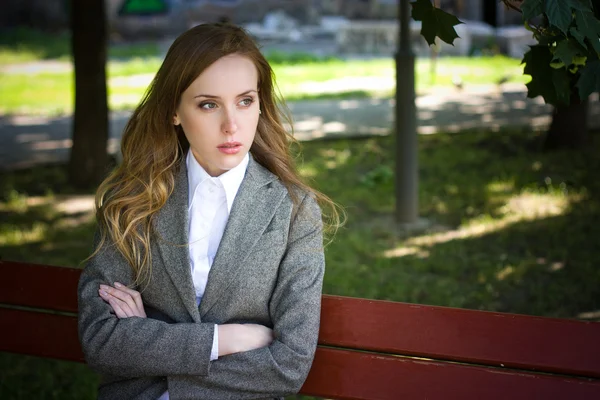 Tearful woman sits on the bench — Stock Photo, Image