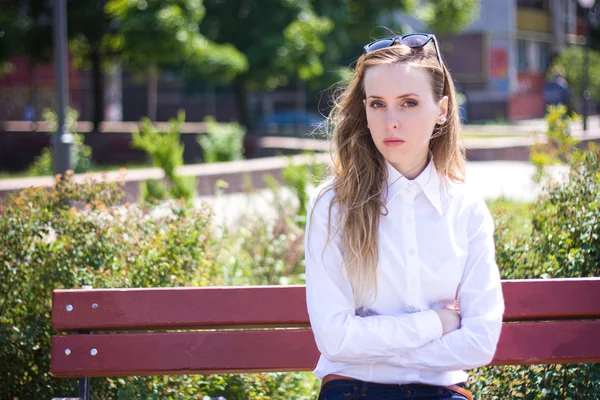 Young woman sits on the bench — Stock Photo, Image