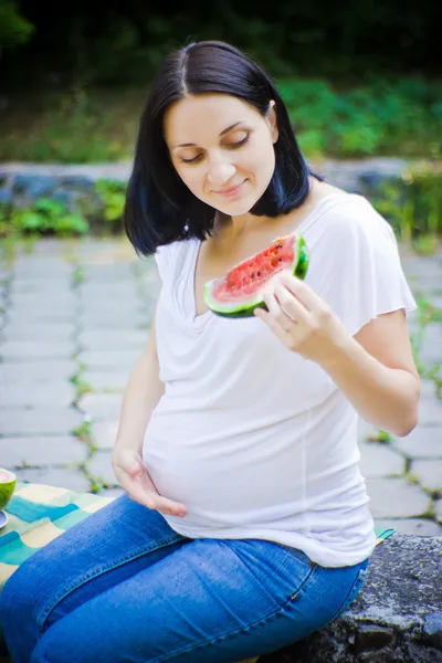 Woman looks on watermelon — Stock Photo, Image