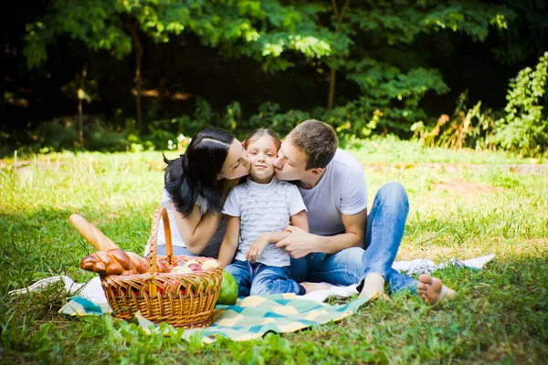 Mother and father kissing daughter — Stock Photo, Image