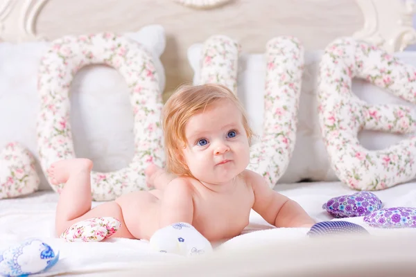 Schattige kleine baby gaat liggen op het bed — Stockfoto