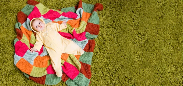 Bambino piccolo si trova sulla coperta colorata — Foto Stock