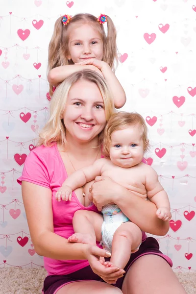 Happy family sits on the carpet — Stock Photo, Image