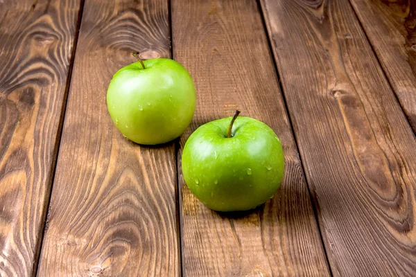 Dos manzanas sobre un fondo de madera Imagen de archivo