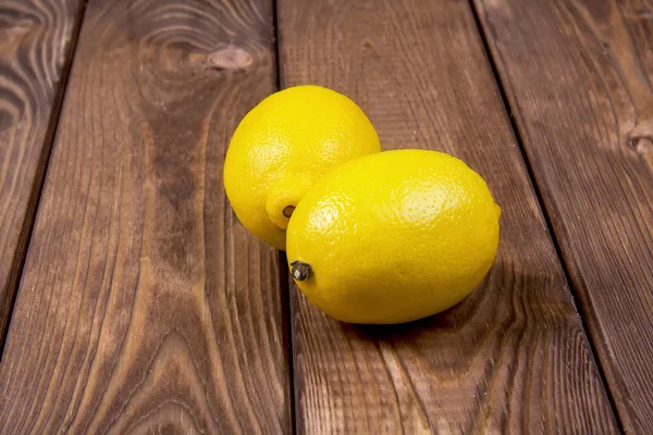 Två citroner på trä bakgrund — Stockfoto