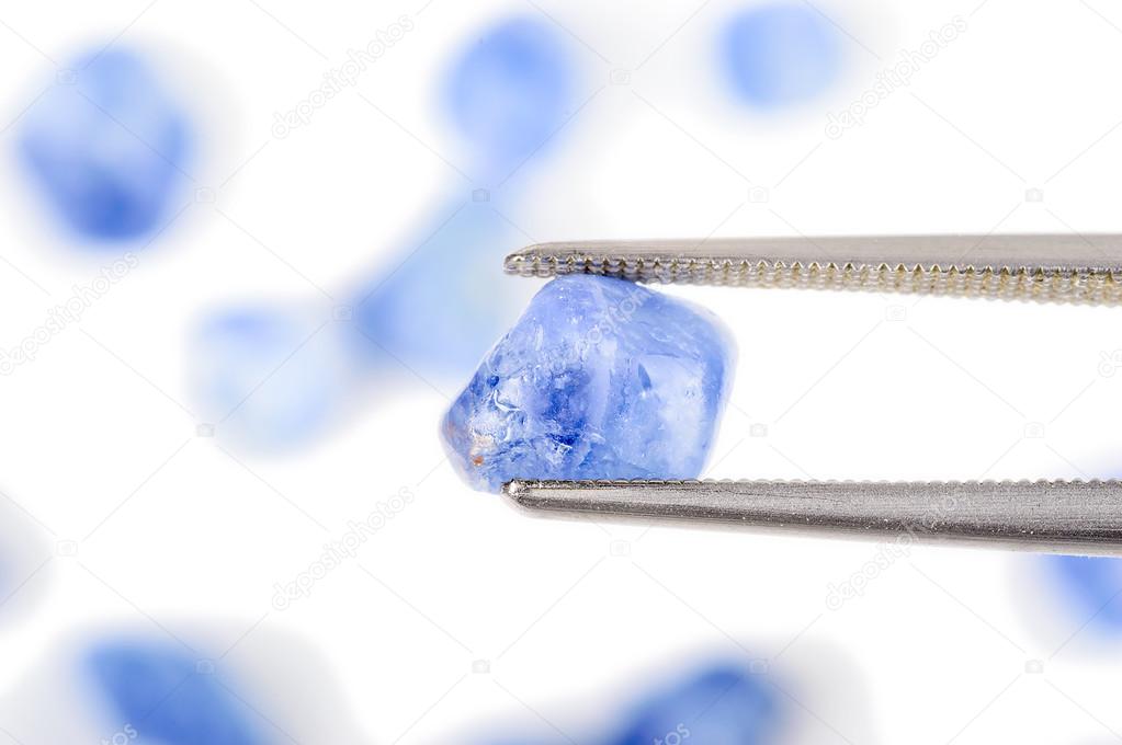Blue sapphire held by twezers