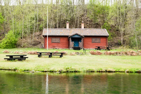 Red house by water — Stock Photo, Image