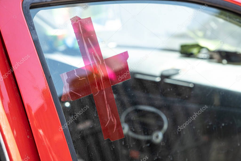 Red cross on the glass of the car. Volunteer help. Medical service. Delivery of food and medicine to people affected by the Russian invasion of Ukraine. Selective focus