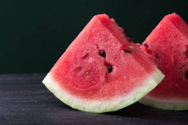 Karanlık ahşap arka planda ferahlatıcı karpuz parçaları. Yakın plan fotoğraf. Meyve dokusu. Yüksek kalite fotoğraf