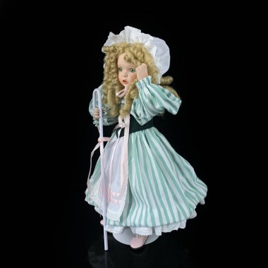 Siyah arka planda izole edilmiş porselen bebek. Seramik çoban kızı, mavi elbiseli.