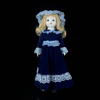 Siyah arka planda izole edilmiş porselen bebek. mavi elbiseli seramik yaşlı bebek  