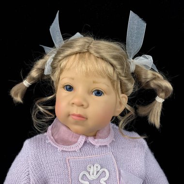 Siyah arka planda izole edilmiş porselen bebek. Pembe takım elbiseli seramik yaşlı bir bebek.