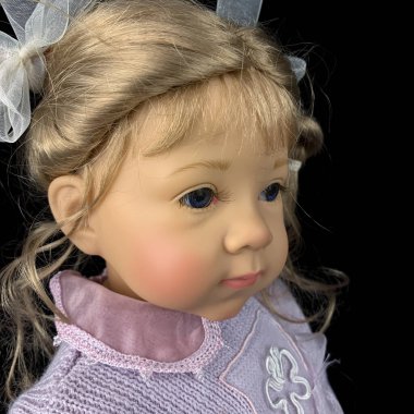 Siyah arka planda izole edilmiş porselen bebek. Pembe takım elbiseli seramik yaşlı bir bebek.