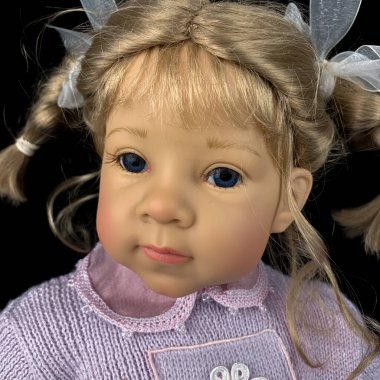 Siyah arka planda izole edilmiş porselen bebek. Pembe takım elbiseli seramik yaşlı bir bebek.