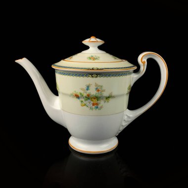 Elle boyanmış antika bir çaydanlık. Siyah izole arka planda çiçek desenli retro çay seti