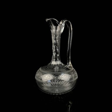 Geometrik desenli antika cam sürahi. Siyah izole edilmiş arka planda alkolün retro sürahisi. Oymalı vintage sürahi