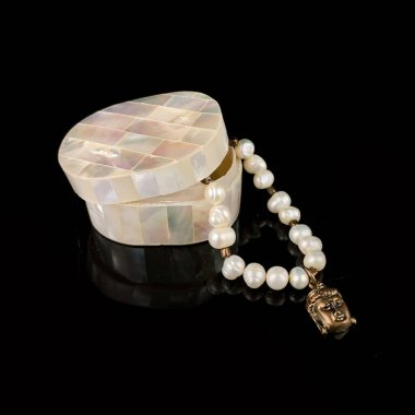 Kutudaki antika mücevherler. Buda kafalı antika inci bilezik. Siyah arka planda antika bilezik.