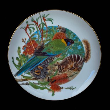 Sonbaharın parlak arka planı, iki renkli papağan bir dala oturur. Yuvarlak. El boyalı antika bir tabak. dekupaj için kuşların görüntüsü ile resim.