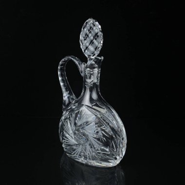 Geometrik desenli antika cam sürahi. Siyah izole edilmiş arka planda alkolün retro sürahisi. Oymalı vintage sürahi