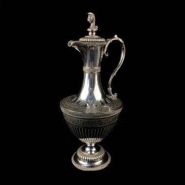 Üzerinde antik gümüş sürahi işlenmiş. Siyah izole arkaplanda çiçek desenli klasik metal oyması.