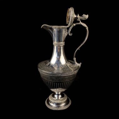 Üzerinde antik gümüş sürahi işlenmiş. Siyah izole arkaplanda çiçek desenli klasik metal oyması.