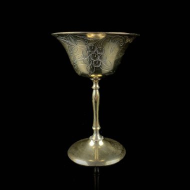 İşlemeli antika bakır cam. Siyah izole edilmiş arka planda çiçek desenli klasik altın şarap kadehi.