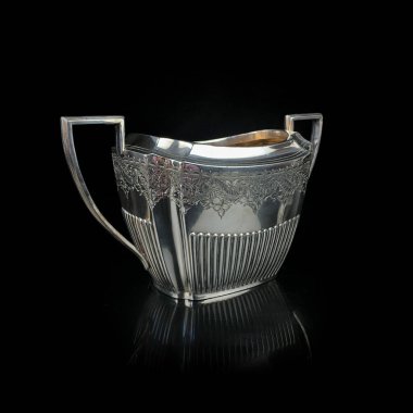 Antika metal şeker kasesi. Gümüş şeker kasesi. Antika gümüş servis .metal şeker kasesi. Üzerinde siyah izole bir arkaplan oyması var.