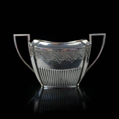 Antika metal şeker kasesi. Gümüş şeker kasesi. Antika gümüş servis .metal şeker kasesi. Üzerinde siyah izole bir arkaplan oyması var.