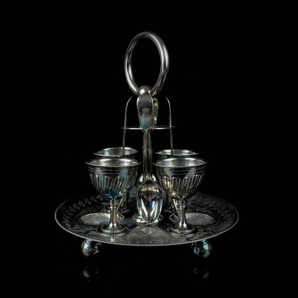 silver antique set of glasses on a stand with engraving. metal vintage set of glasses for alcoholic drinks on a black isolated background