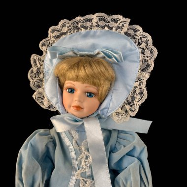 Siyah arka planda izole edilmiş porselen bebek. antika mavi elbiseli seramik eski bir bebek. Yakın plan.