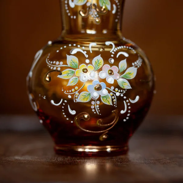 antique orange glass vase with flower pattern in luxury interior. hand-painted crystal vase