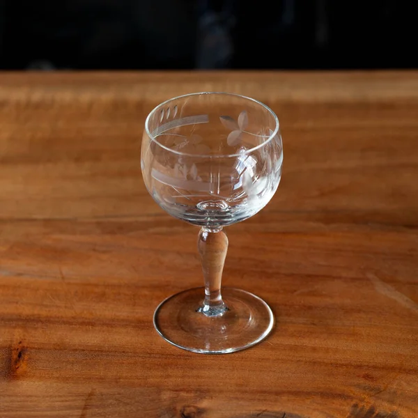 antique transparent glass wine glass on a black background. crystal glass with engraving. glass close-up