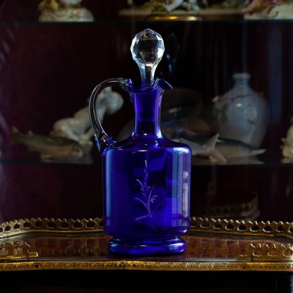 antique blue glass vase in luxury interior. engraved crystal decanter. glass close-up