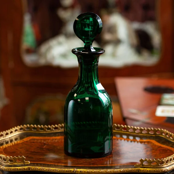 set of glass green bottles in luxury interior. crystal green bottle. bohemian glass closeup