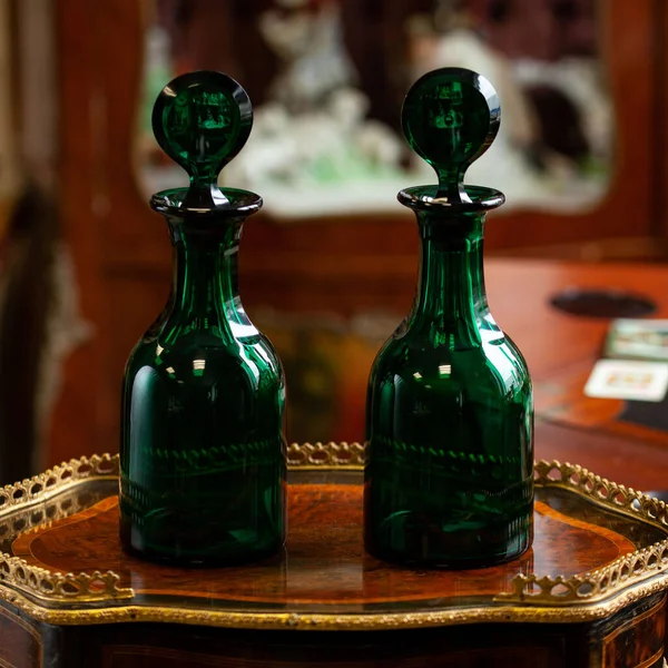 set of glass green bottles in luxury interior. crystal green bottle. bohemian glass closeup