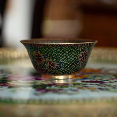 stained glass dish in a luxurious interior. crystal green plate with floral pattern. bohemian glass closeup