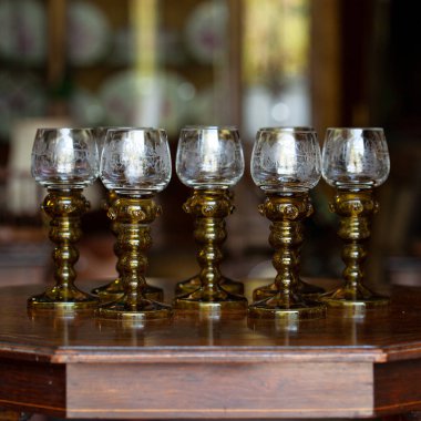 Şatafatlı bir iç mekanda cam kadehler. Altın antika kadeh yakın plan. Bohem camı yakın çekim.