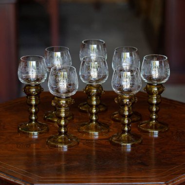 Şatafatlı bir iç mekanda cam kadehler. Altın antika kadeh yakın plan. Bohem camı yakın çekim.