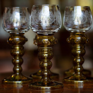 Şatafatlı bir iç mekanda cam kadehler. Altın antika kadeh yakın plan. Bohem camı yakın çekim.