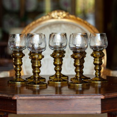 Şatafatlı bir iç mekanda cam kadehler. Altın antika kadeh yakın plan. Bohem camı yakın çekim.