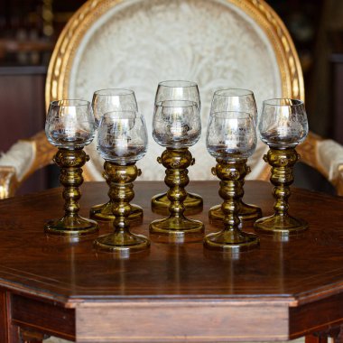 Şatafatlı bir iç mekanda cam kadehler. Altın antika kadeh yakın plan. Bohem camı yakın çekim.