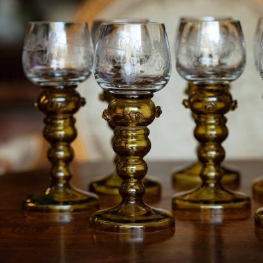 Şatafatlı bir iç mekanda cam kadehler. Altın antika kadeh yakın plan. Bohem camı yakın çekim.