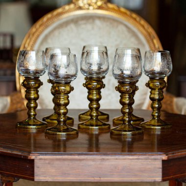 Şatafatlı bir iç mekanda cam kadehler. Altın antika kadeh yakın plan. Bohem camı yakın çekim.