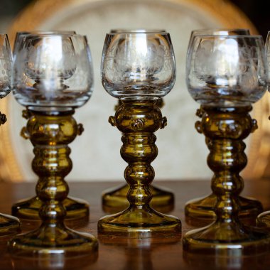 Şatafatlı bir iç mekanda cam kadehler. Altın antika kadeh yakın plan. Bohem camı yakın çekim.