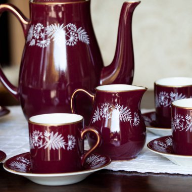 Ulusal boyalı antika koyu kırmızı porselen servisi. Lüks bir iç mekanda Ukrayna usulü hizmet. seramik yakın çekim